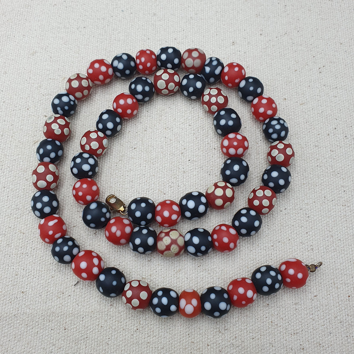 Collier de perles vintage africain en verre mouffette, points blancs, rouge et noir