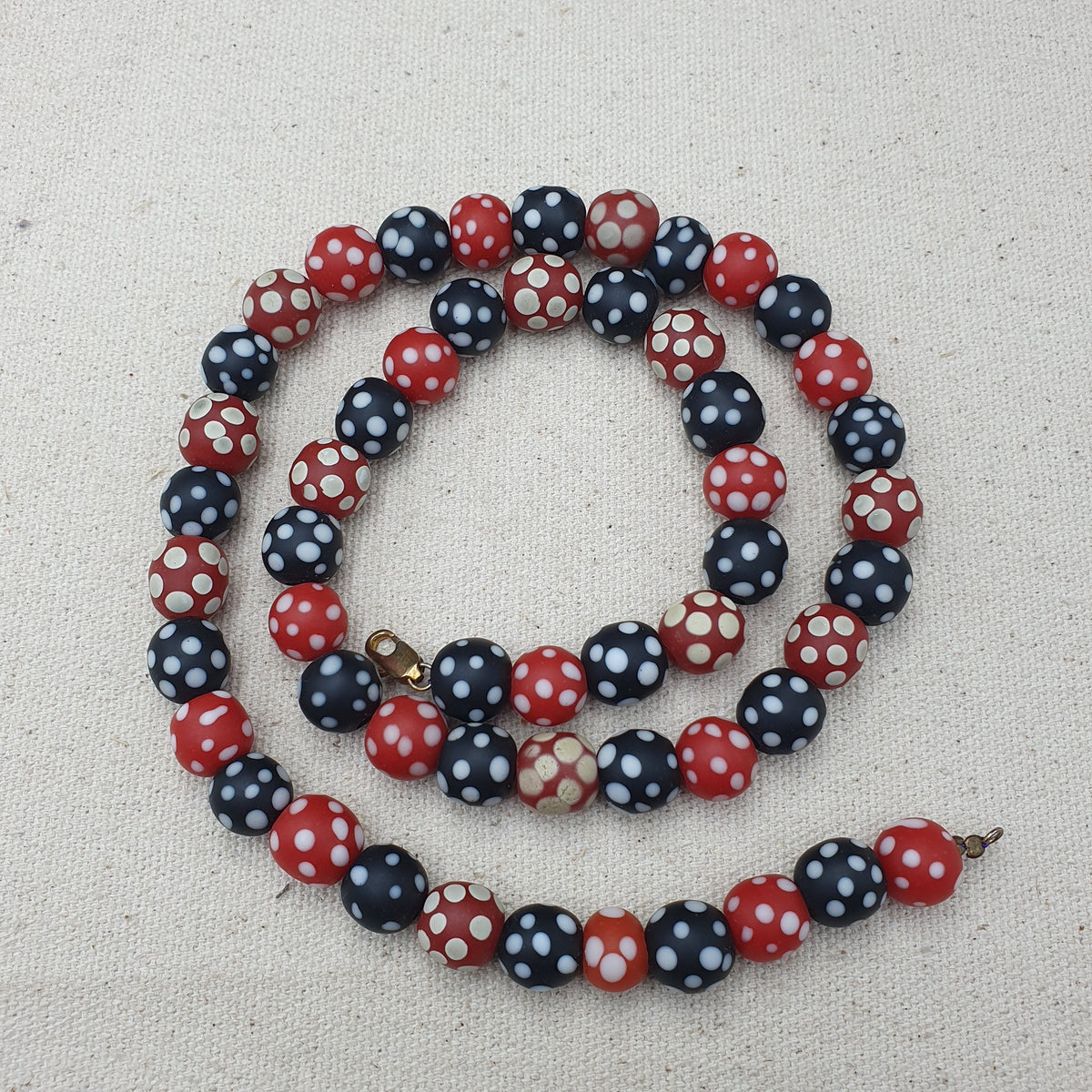 Collier de perles vintage africain en verre mouffette, points blancs, rouge et noir