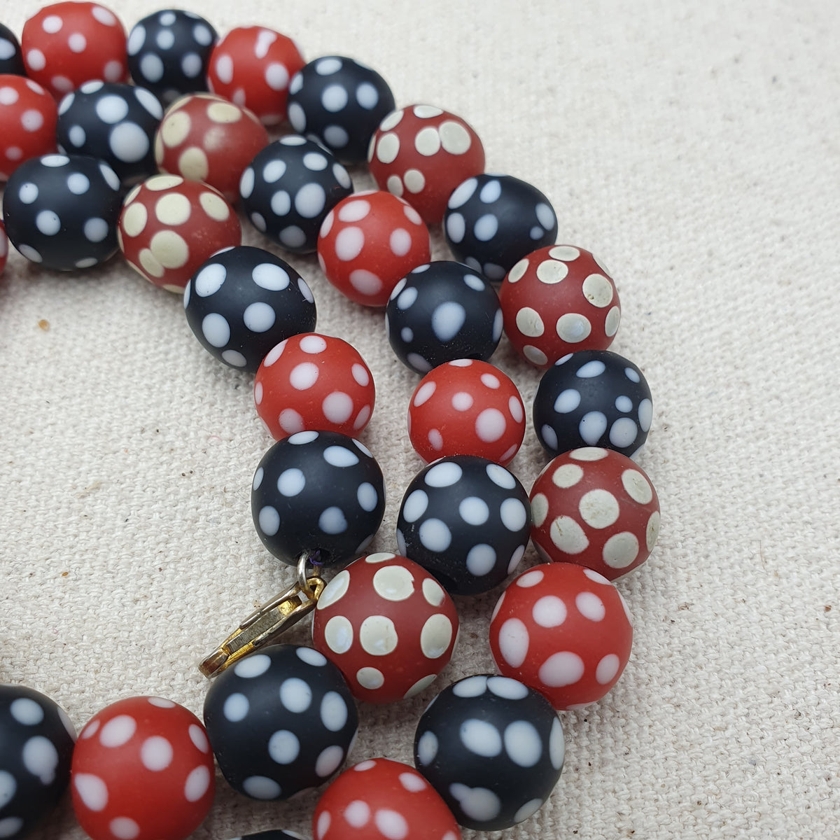 Collier de perles vintage africain en verre mouffette, points blancs, rouge et noir