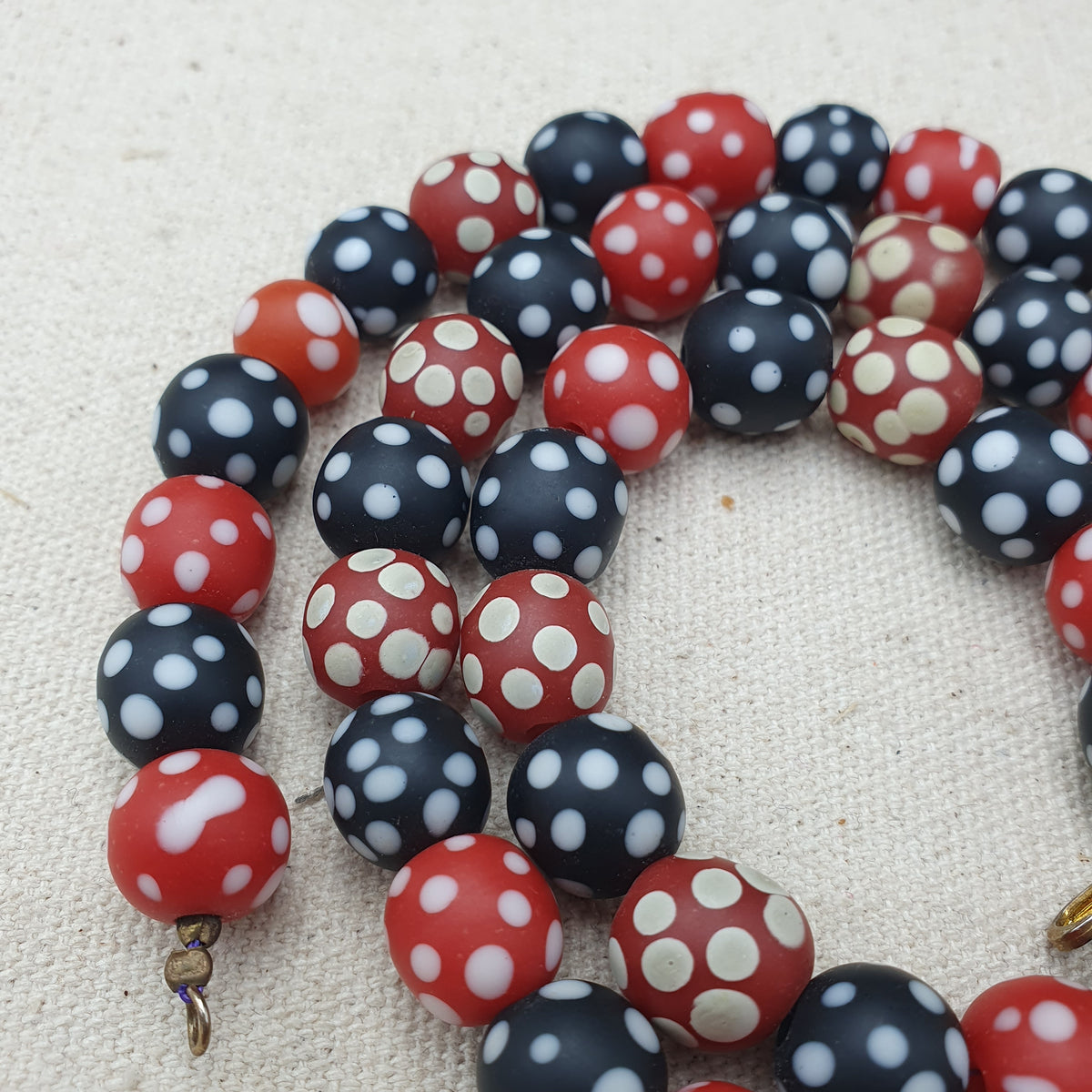 Collier de perles vintage africain en verre mouffette, points blancs, rouge et noir
