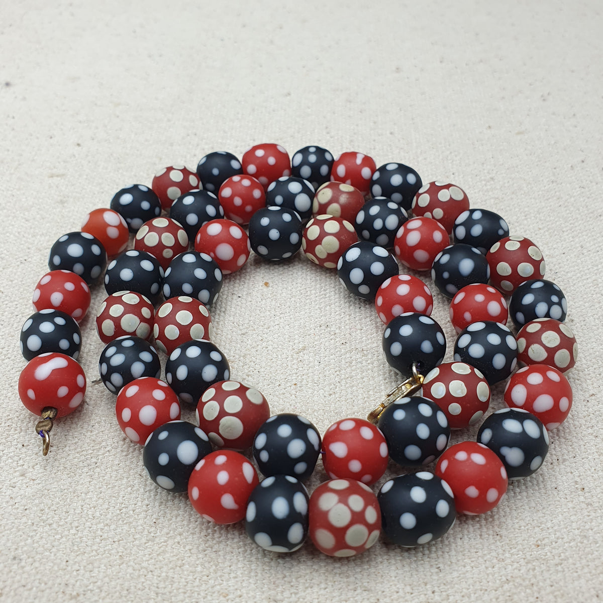 Collier de perles vintage africain en verre mouffette, points blancs, rouge et noir