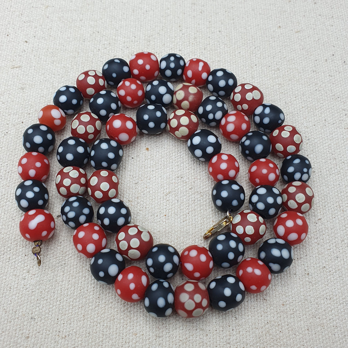Collier de perles vintage africain en verre mouffette, points blancs, rouge et noir