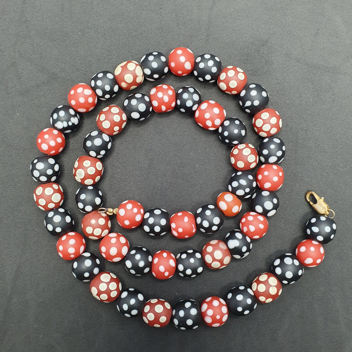 Collier de perles vintage africain en verre mouffette, points blancs, rouge et noir