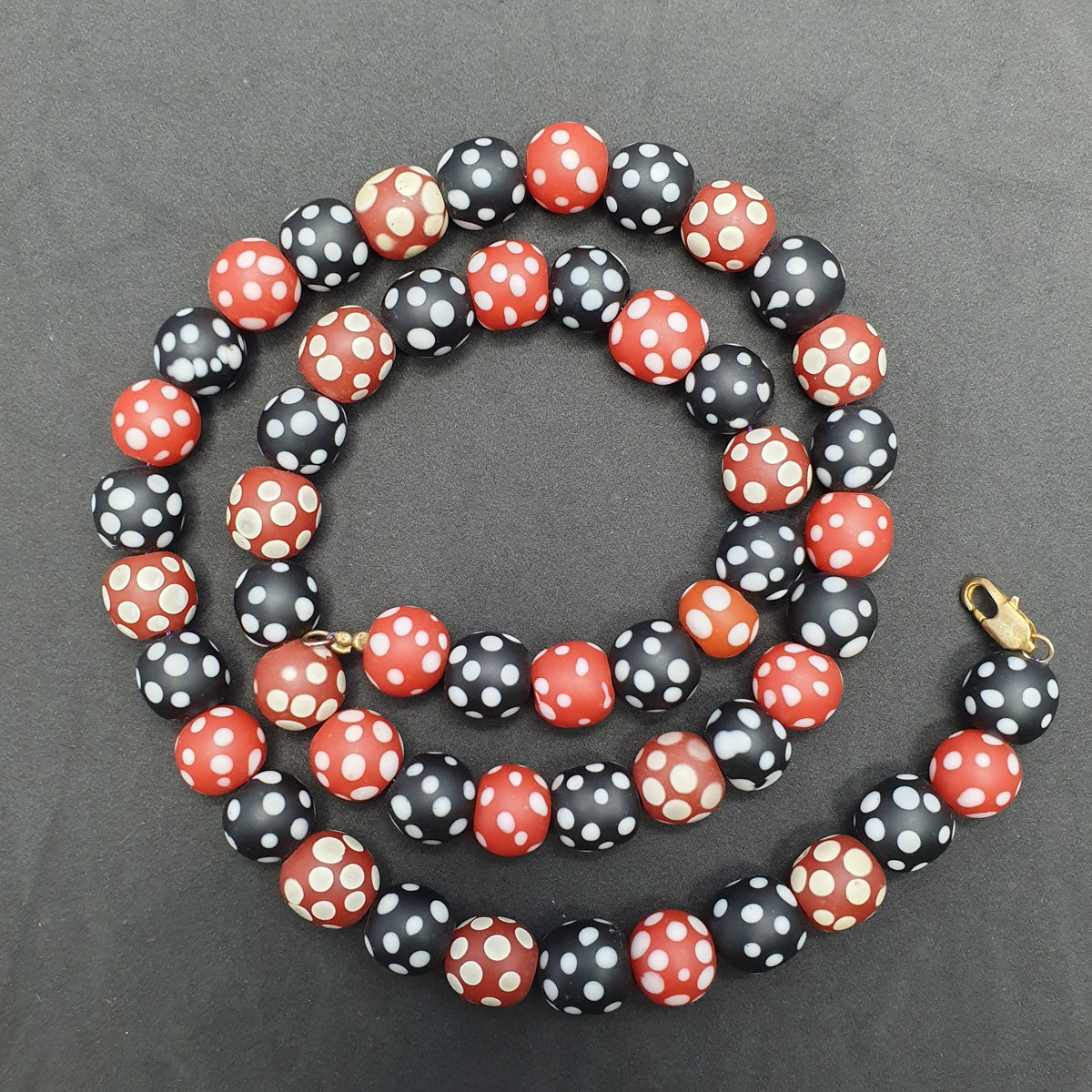 Collier de perles vintage africain en verre mouffette, points blancs, rouge et noir