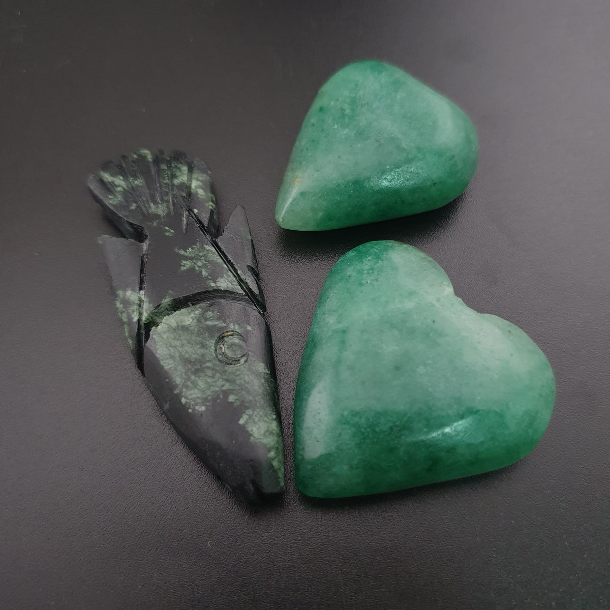 Lot de 3 pendentifs vintage en jade sculpté : un en forme de poisson, deux en forme de cœur vert.