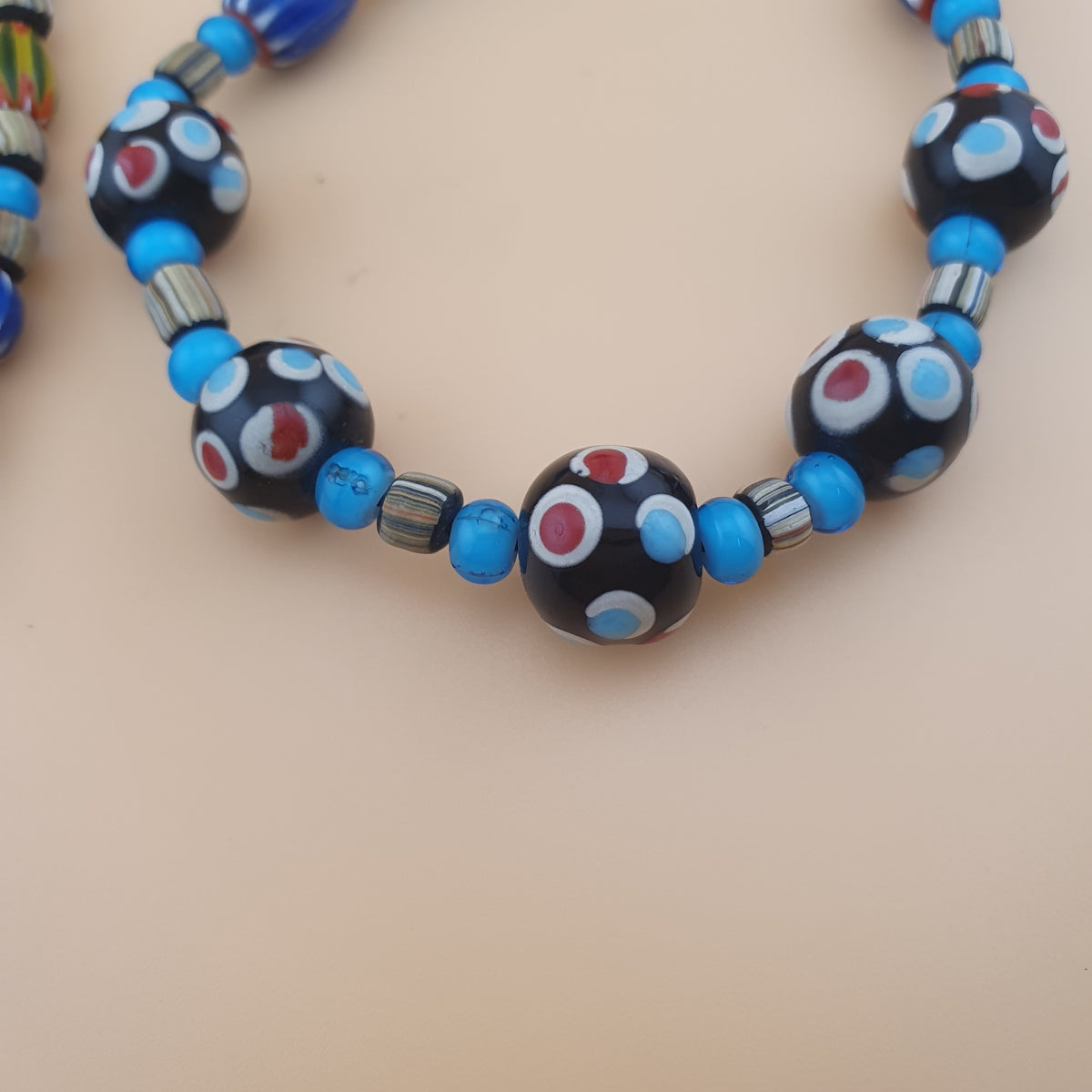 Collier en perles de verre vintage, motif chevron et cœur blanc avec yeux