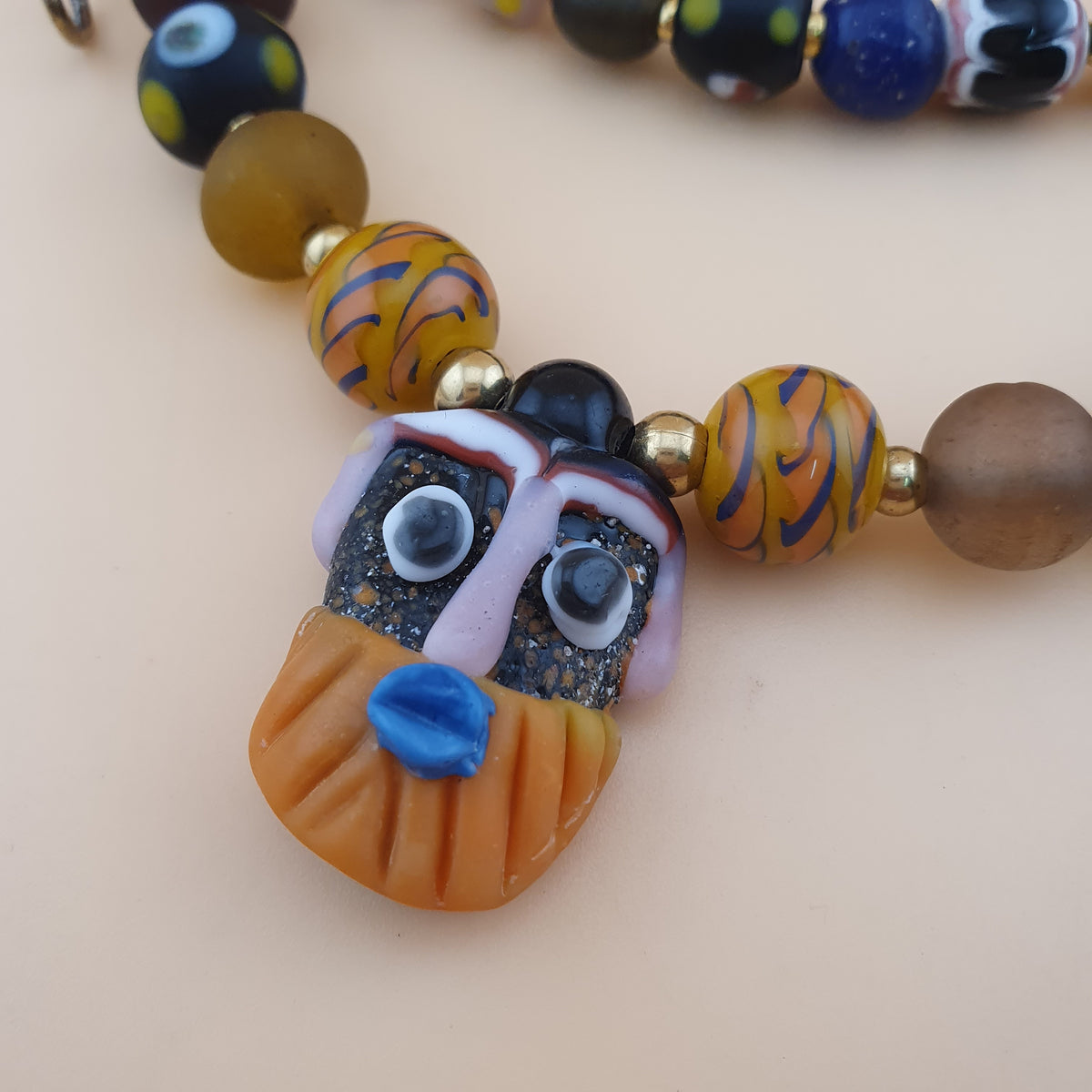 Collier pendentif ancien en perles de verre mélangées de style vénitien avec visage