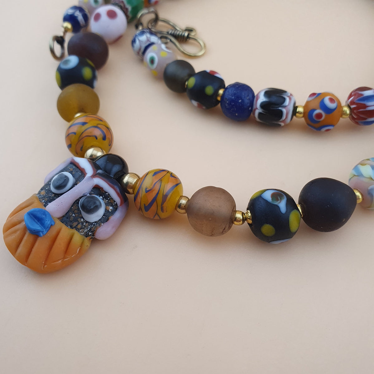 Collier pendentif ancien en perles de verre mélangées de style vénitien avec visage