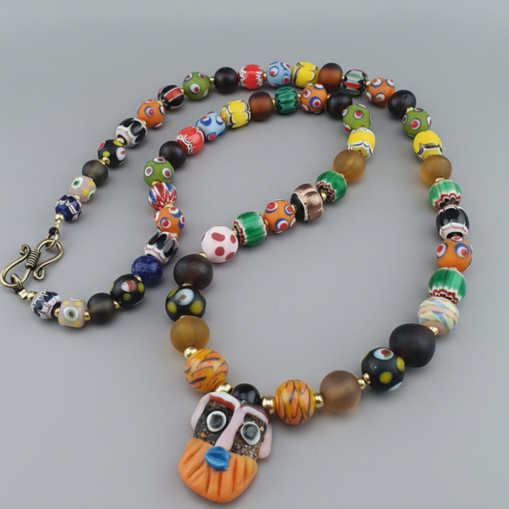Collier pendentif ancien en perles de verre mélangées de style vénitien avec visage