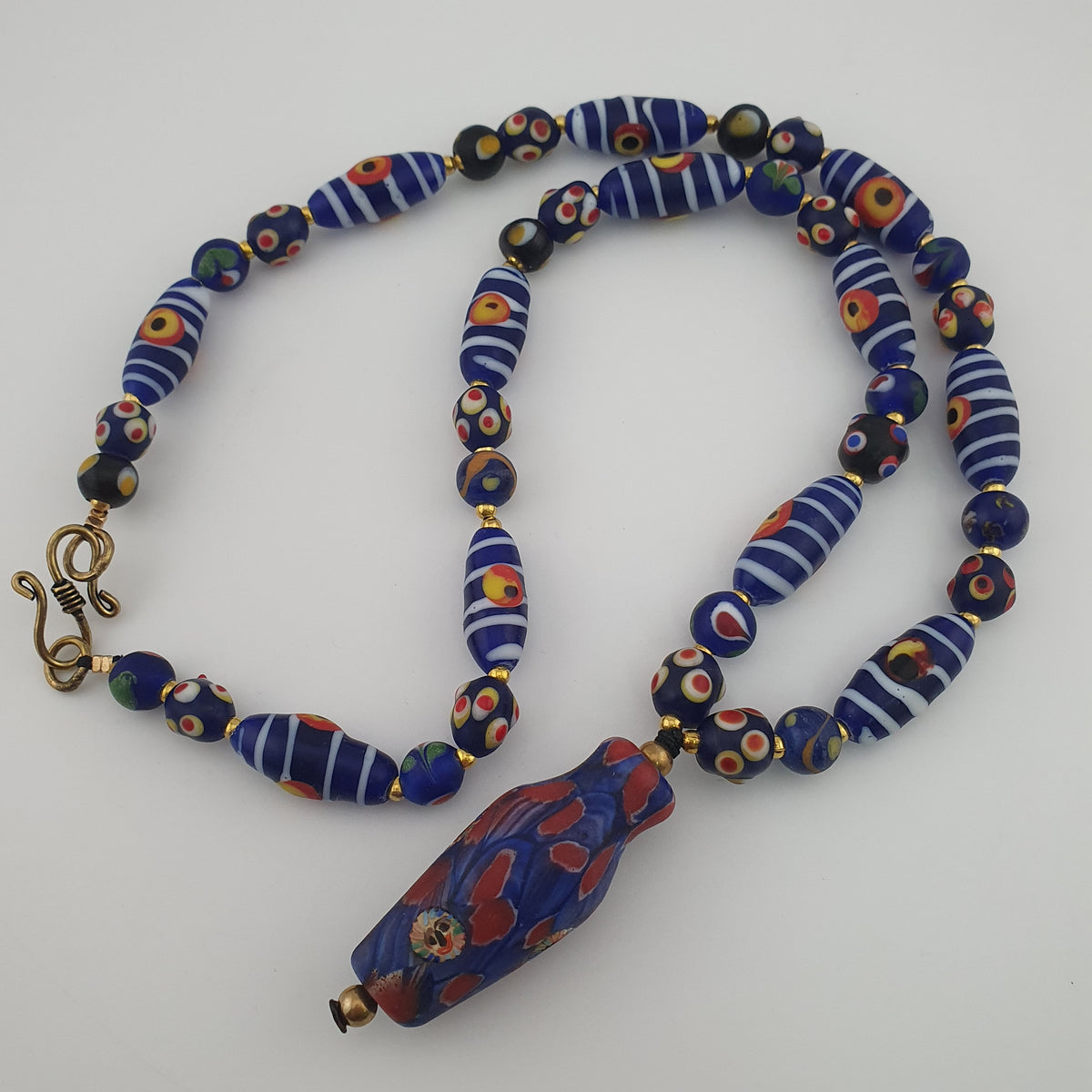 Collier à pendentif en verre, style vénitien antique, rayé avec des yeux de mouffette et un visage ancien