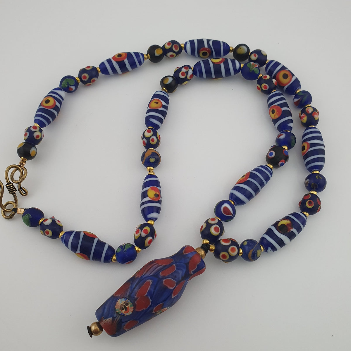 Collier à pendentif en verre, style vénitien antique, rayé avec des yeux de mouffette et un visage ancien