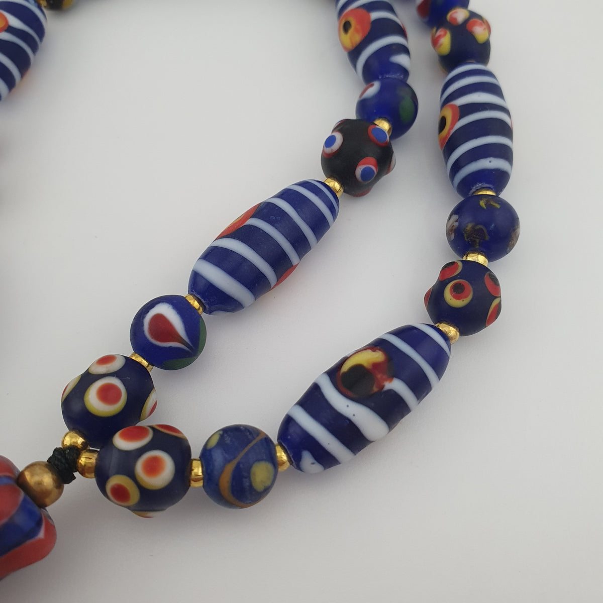 Collier à pendentif en verre, style vénitien antique, rayé avec des yeux de mouffette et un visage ancien