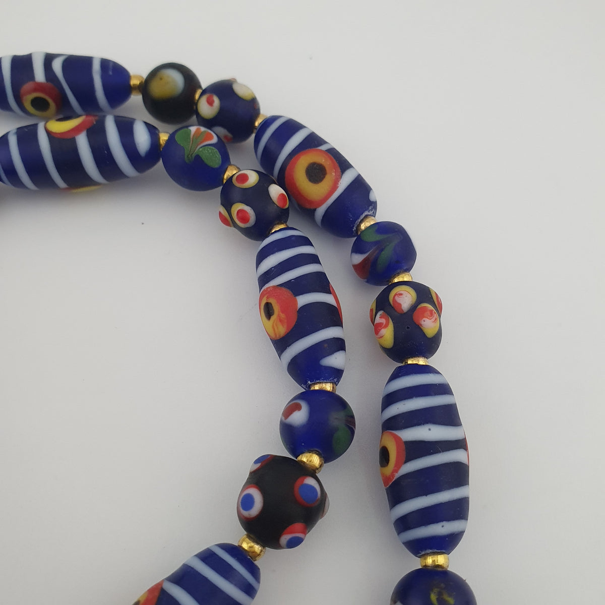 Collier à pendentif en verre, style vénitien antique, rayé avec des yeux de mouffette et un visage ancien