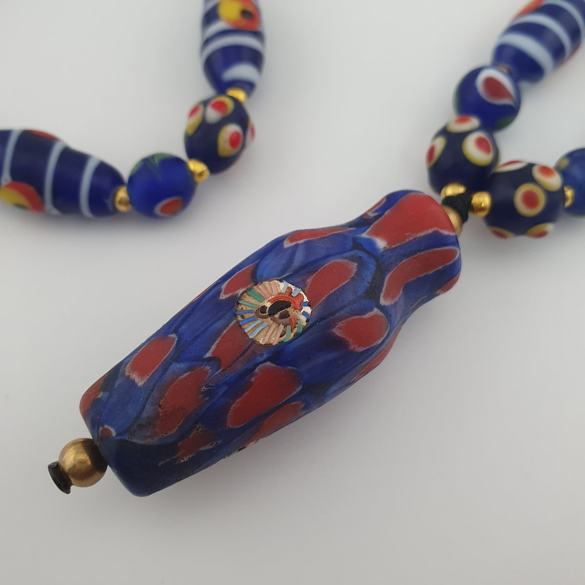 Collier à pendentif en verre, style vénitien antique, rayé avec des yeux de mouffette et un visage ancien