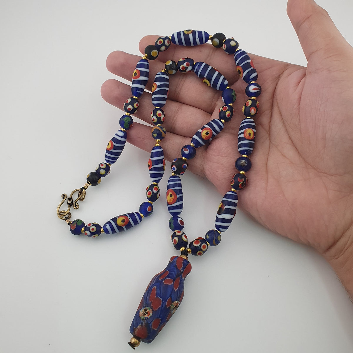 Collier à pendentif en verre, style vénitien antique, rayé avec des yeux de mouffette et un visage ancien