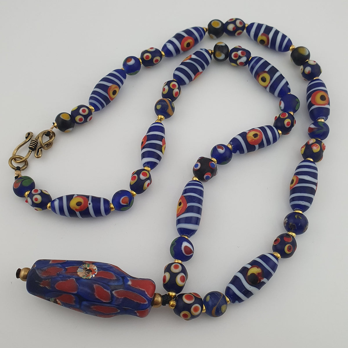 Collier à pendentif en verre, style vénitien antique, rayé avec des yeux de mouffette et un visage ancien