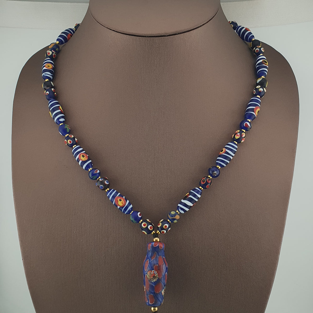 Collier à pendentif en verre, style vénitien antique, rayé avec des yeux de mouffette et un visage ancien