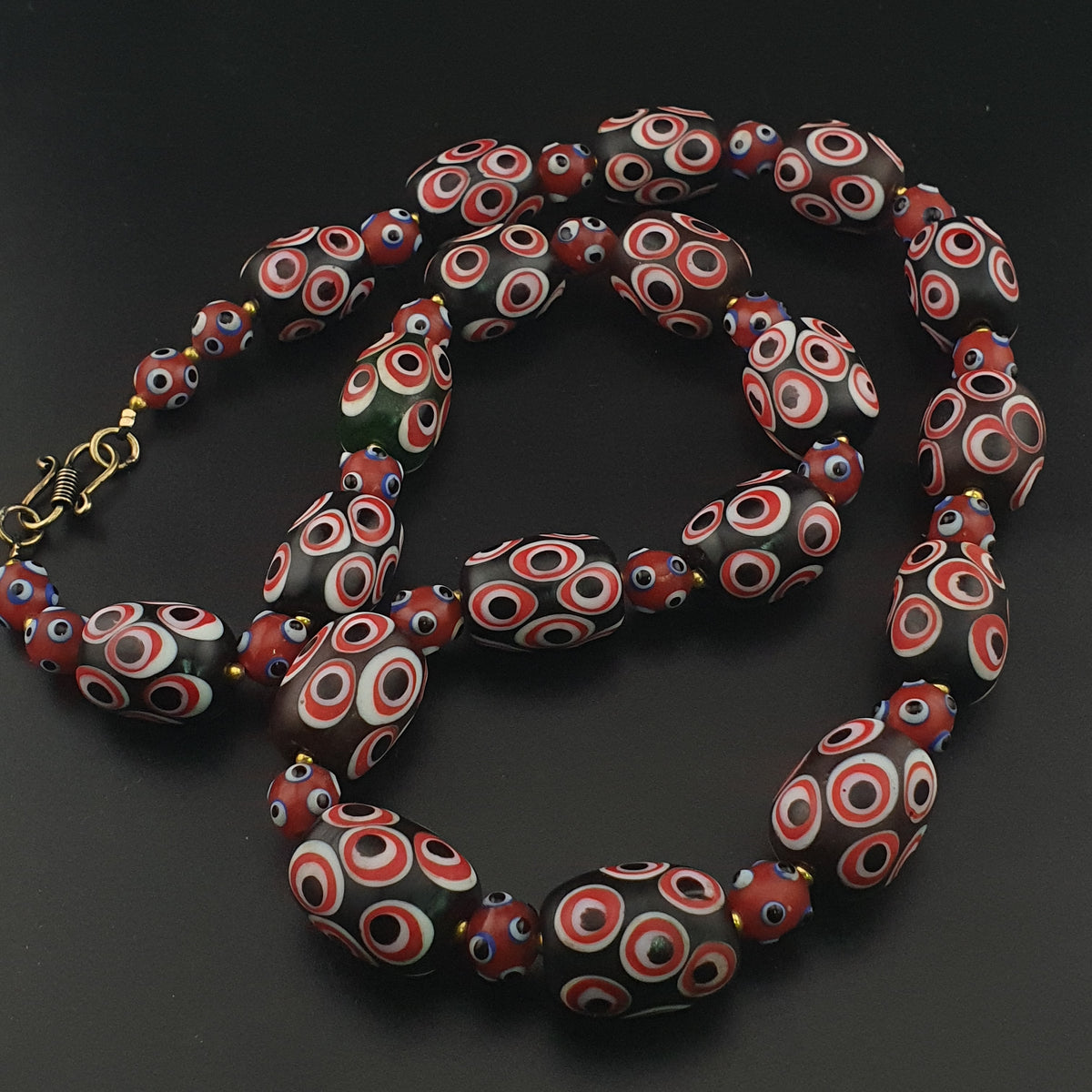 Collier de perles de verre millefiori et œil de moufette rouges antiques de style vénitien